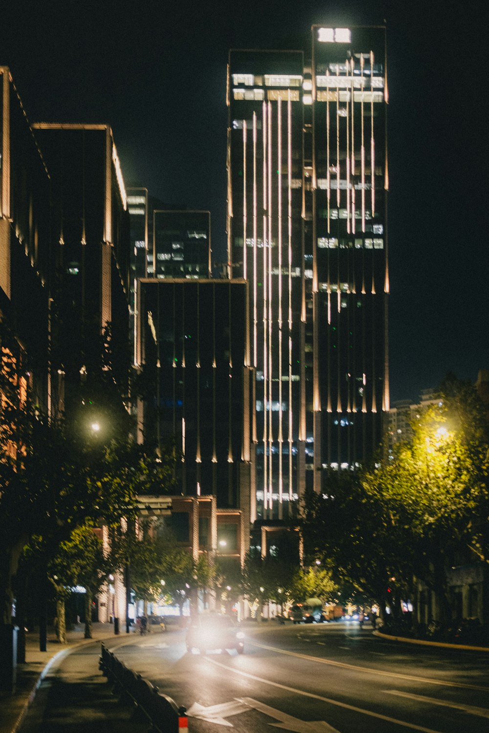 a city street at night with tall buildings