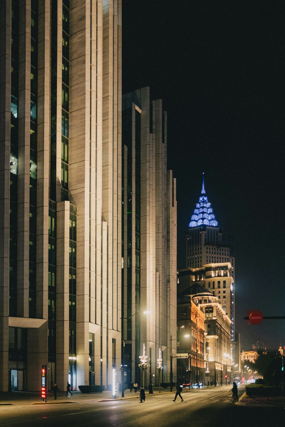 a city street at night with tall buildings