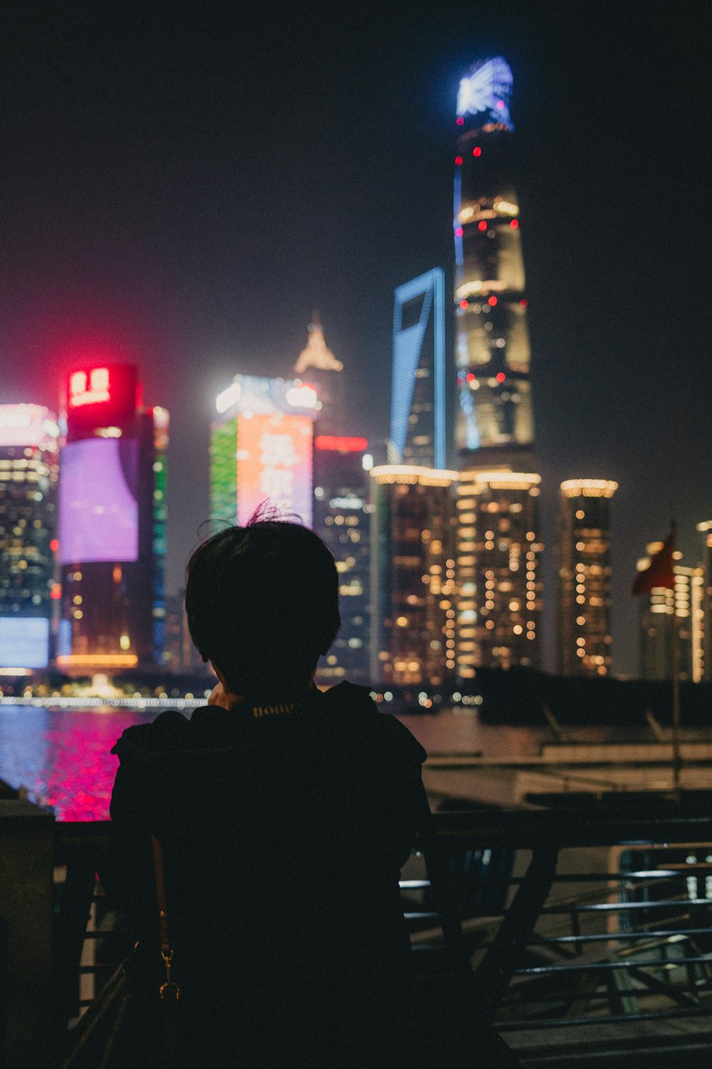 a person sitting on a bench in front of a city skyline