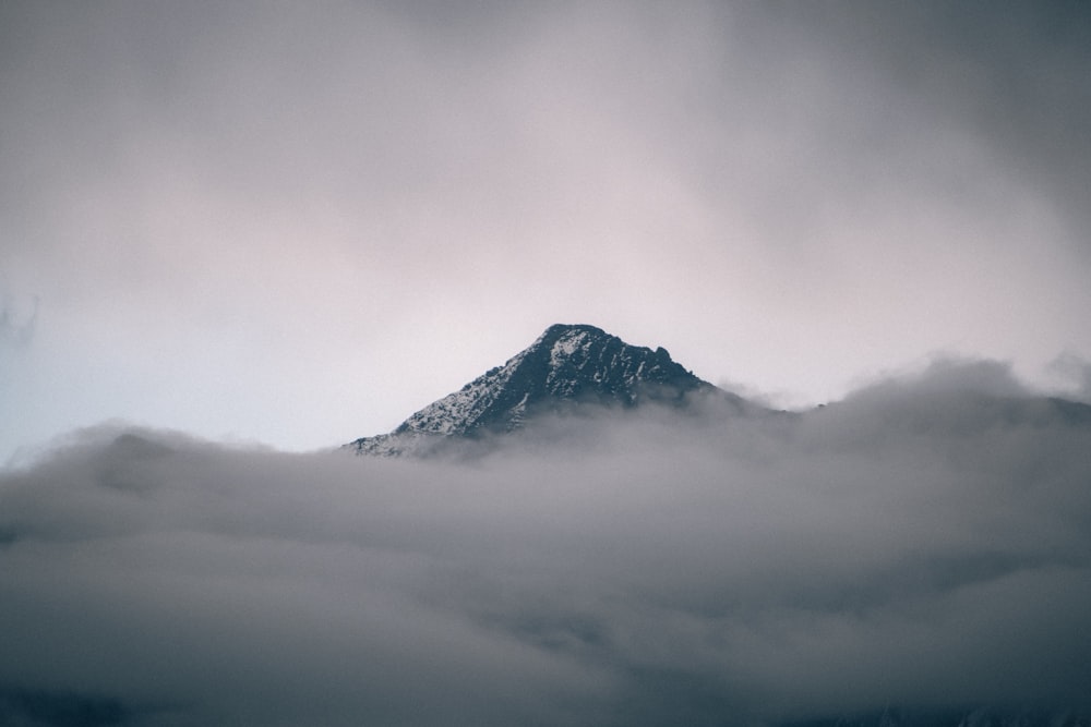 a mountain covered in clouds under a cloudy sky