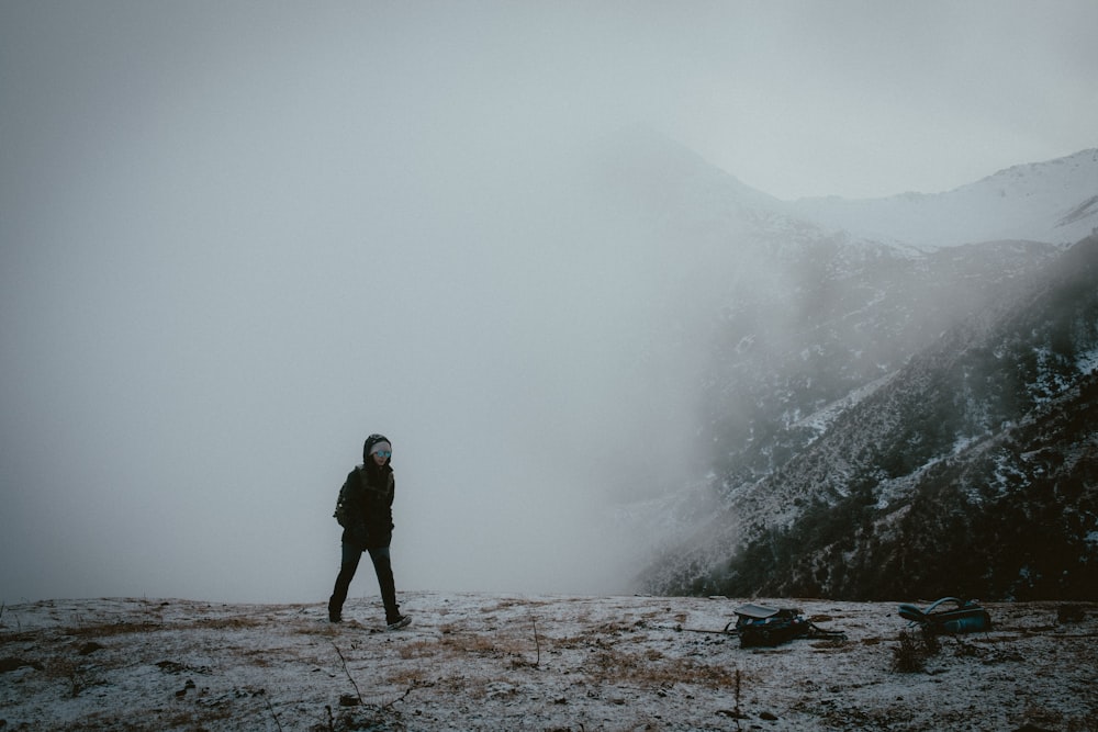 um homem no topo de uma montanha coberta de neve