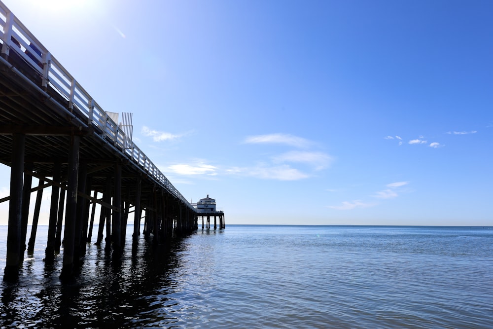 a pier on the ocean with a clear blue sky