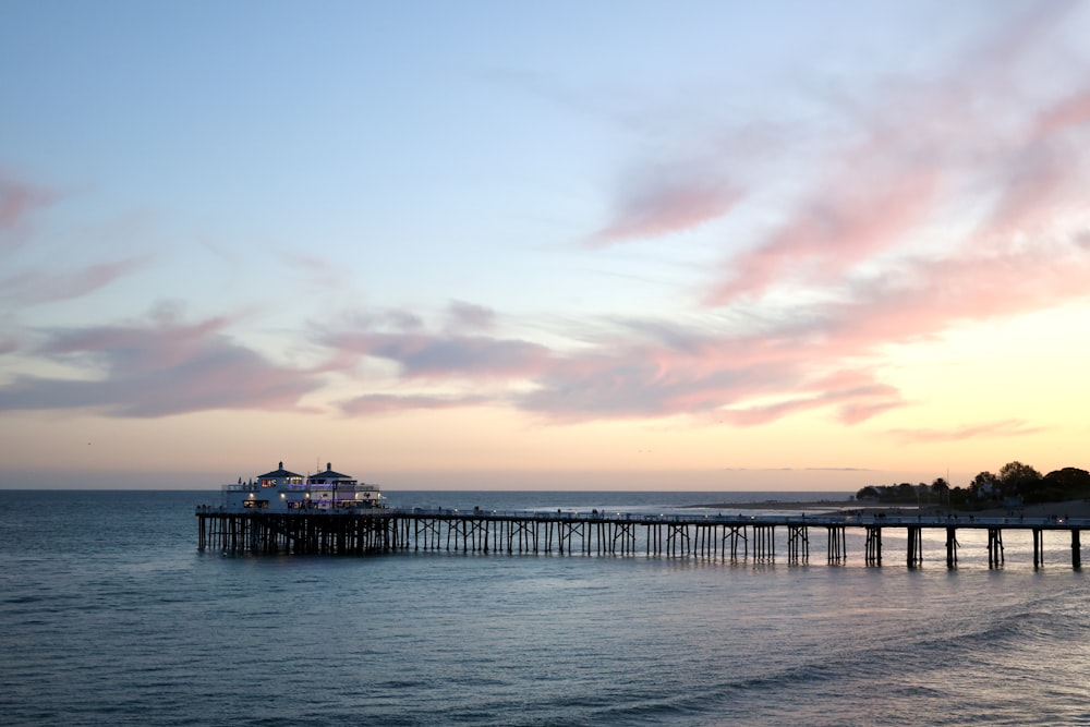 a pier on the water with a sky background