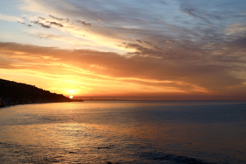 the sun is setting over a body of water