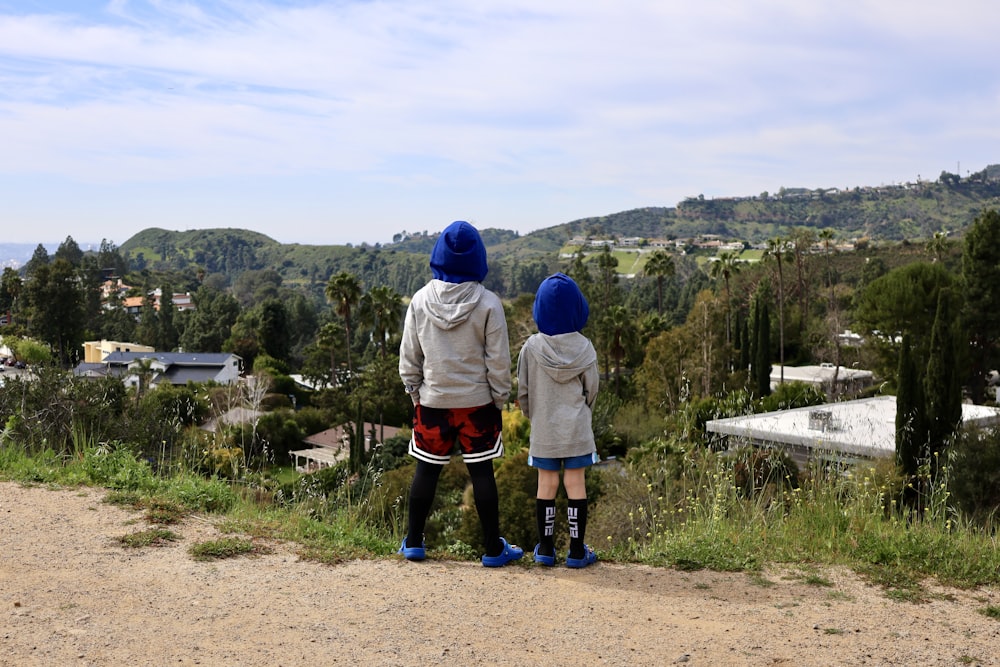 a couple of people standing on top of a dirt road