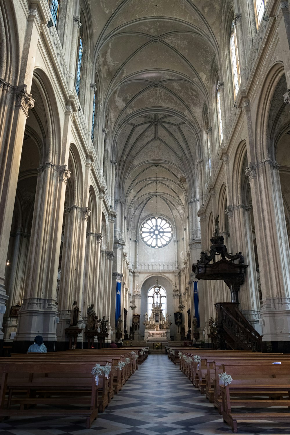 une grande cathédrale avec des bancs et un sol en damier