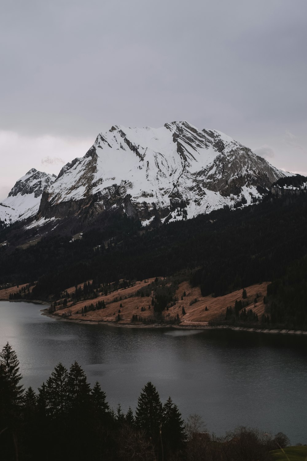 une montagne enneigée avec un lac au premier plan