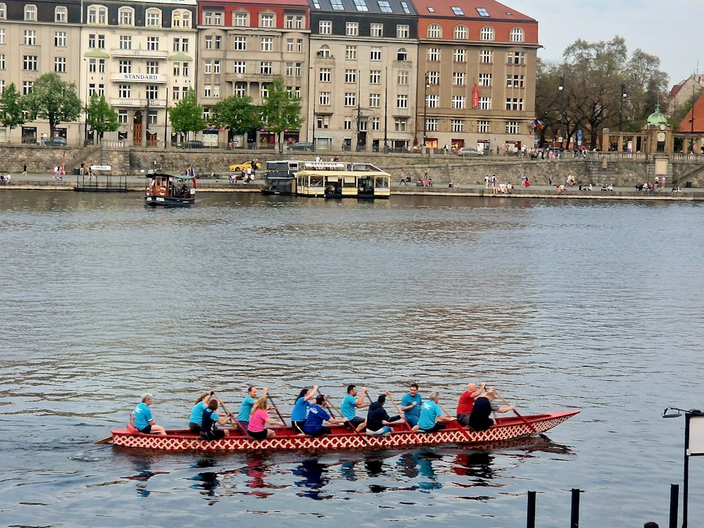 a group of people riding on top of a red boat