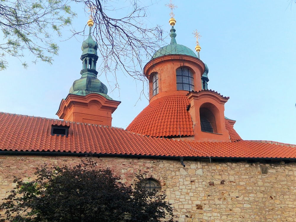 a red brick building with two towers and a cross on top