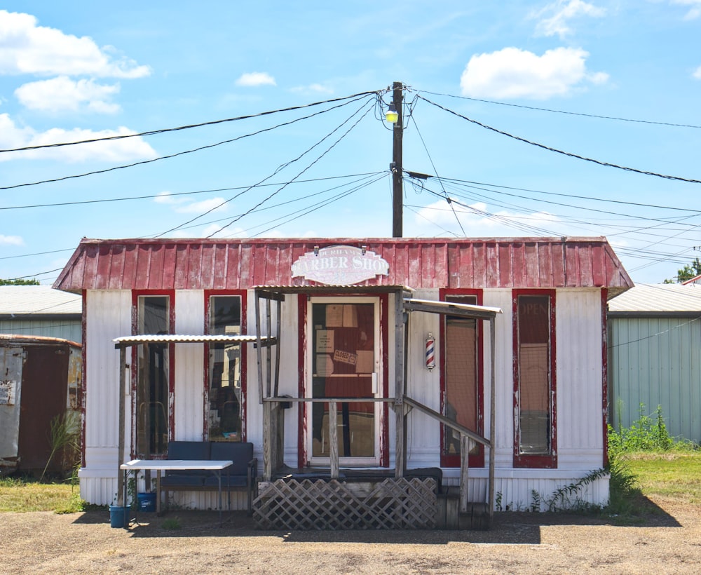 a small red and white building with a bench in front of it