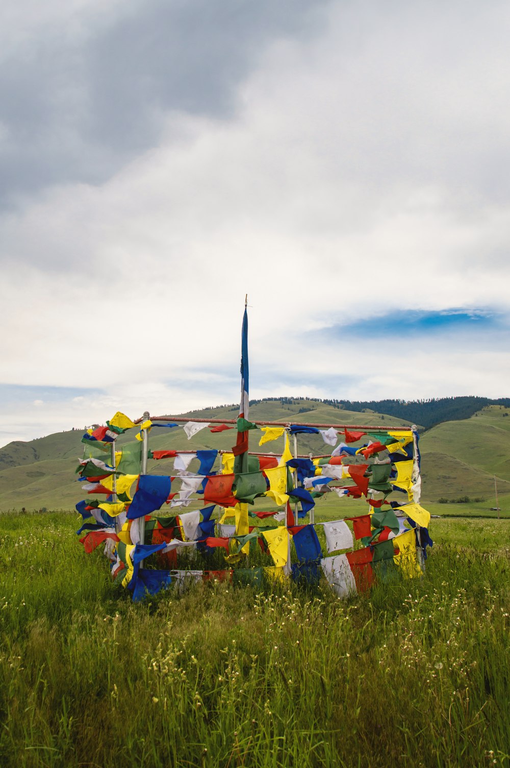 uma escultura em um campo com uma bandeira saindo dele