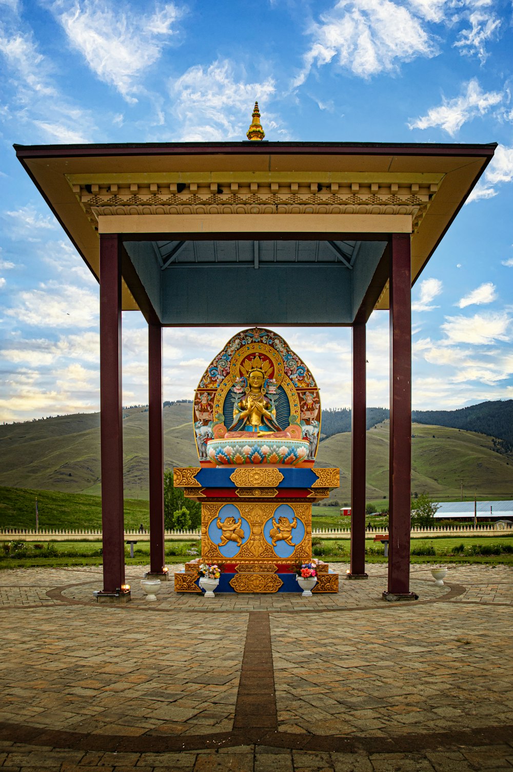 a statue of a buddha in the middle of a park