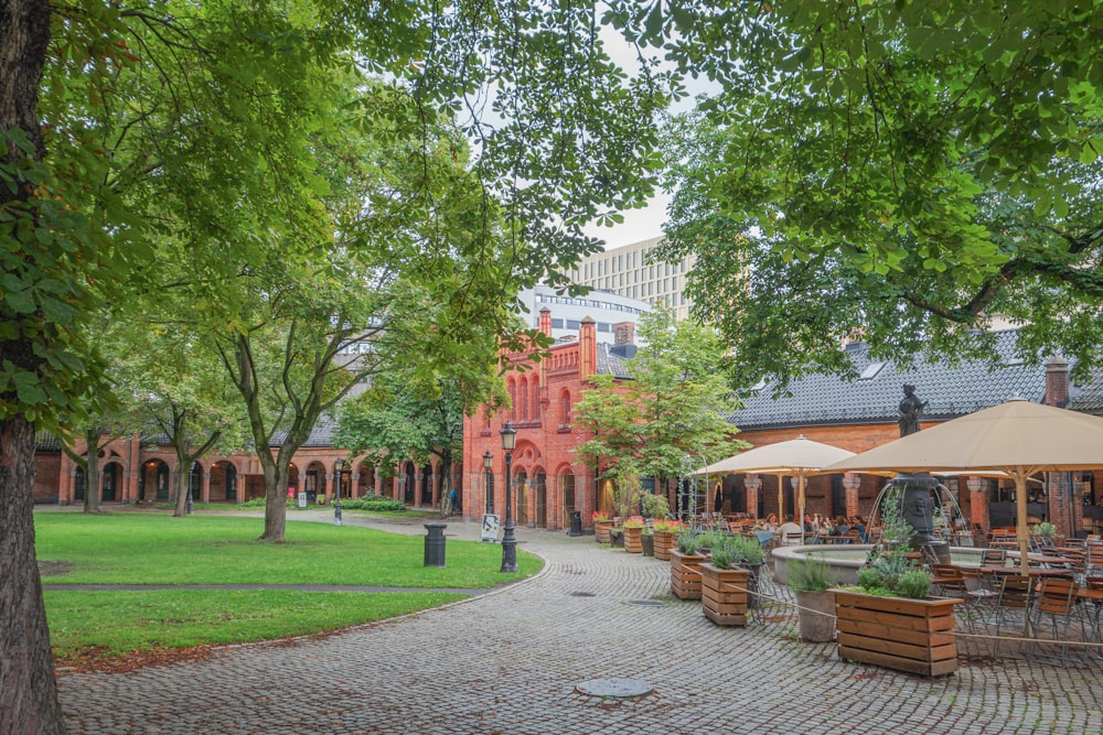 a courtyard with tables, chairs and umbrellas