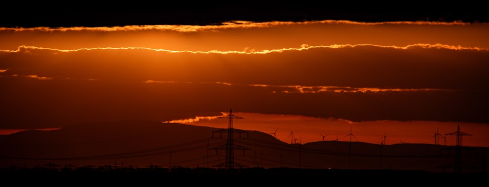 the sun is setting over a mountain range