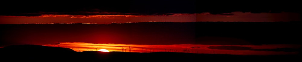 the sun is setting over a mountain range