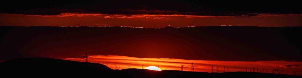 the sun is setting over a mountain range