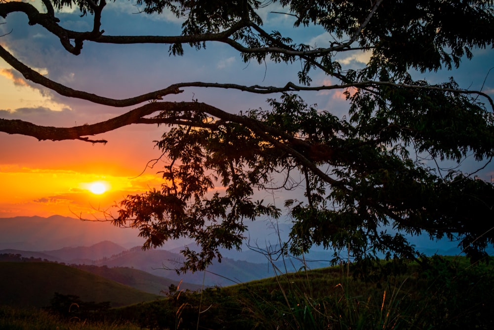 the sun is setting over a mountain range