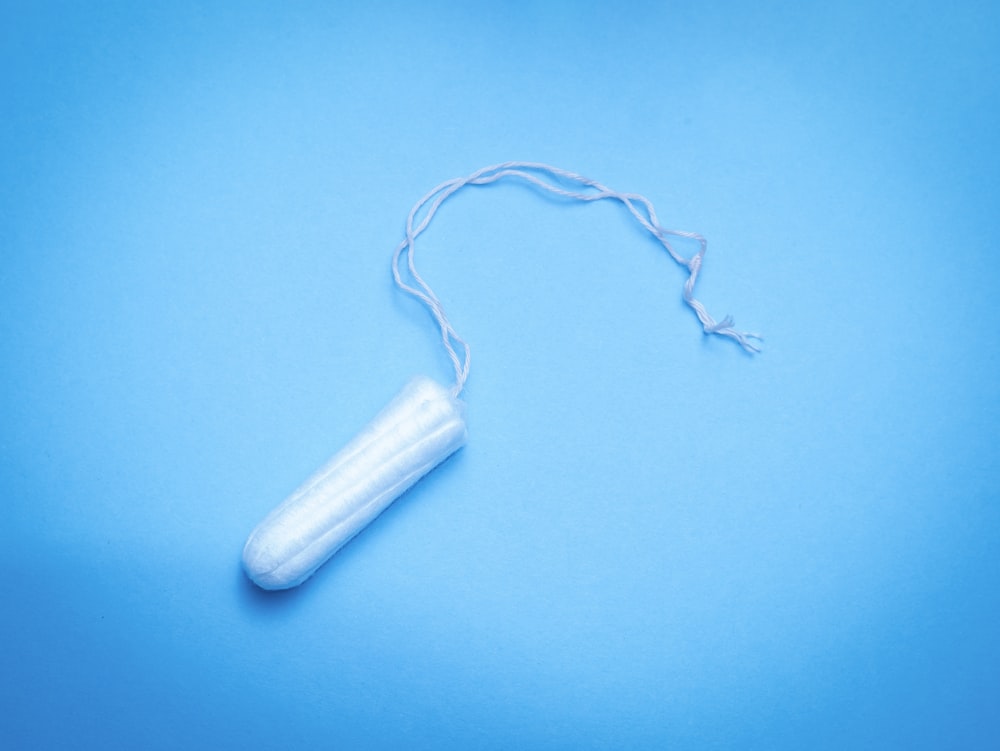 un tubo de plástico de pasta de dientes sobre un fondo azul