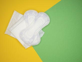 a pair of white cloths sitting on top of a green and yellow background