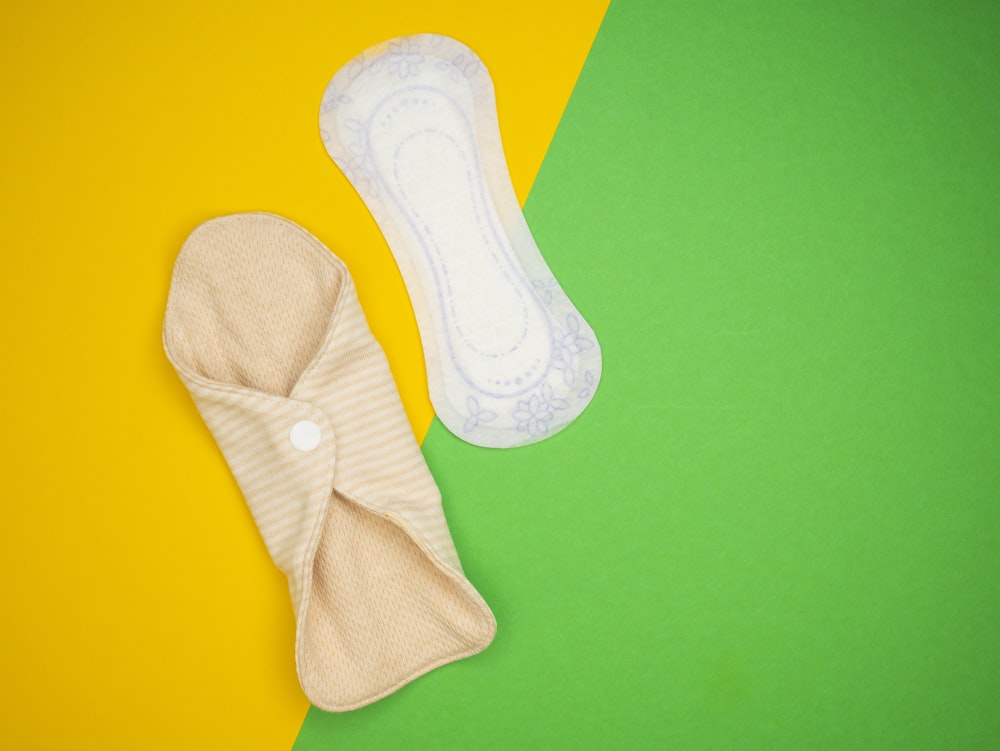un par de calcetines de bebé y un pañal sobre fondo verde y amarillo