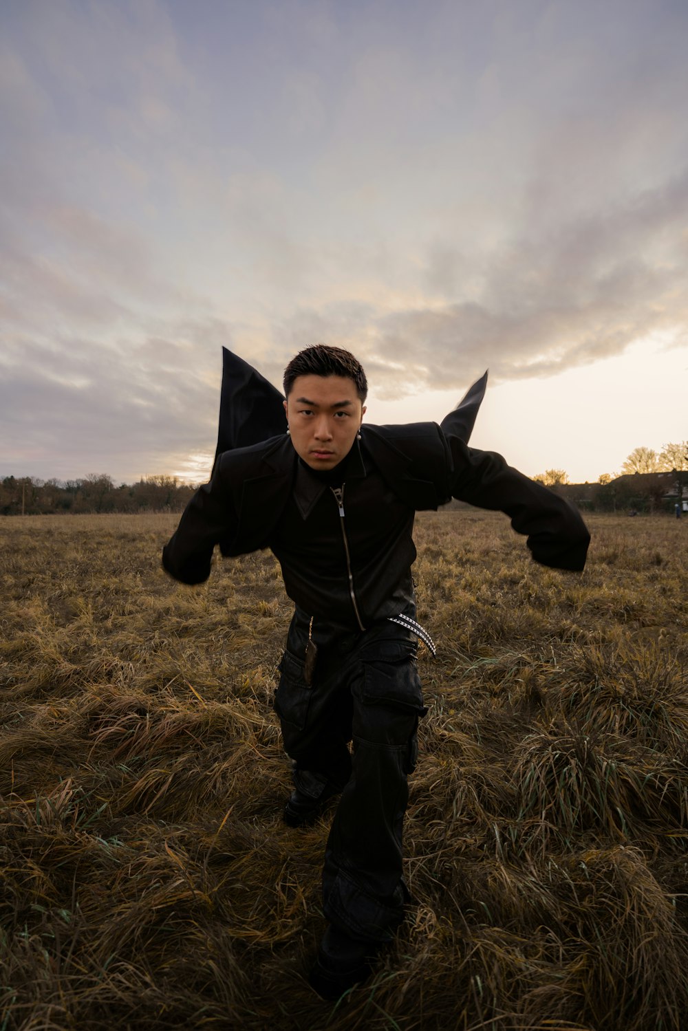 a man in a field with his arms spread out