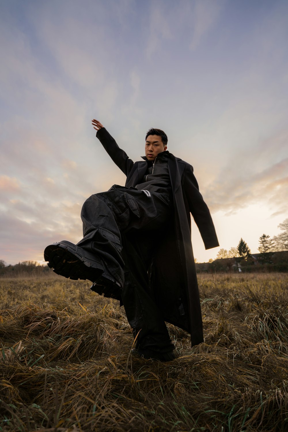 a man in a black coat is in a field