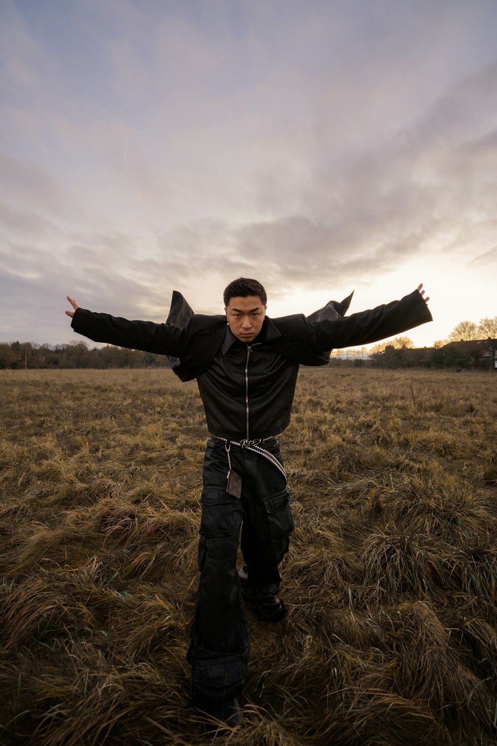 a man standing in a field with his arms outstretched