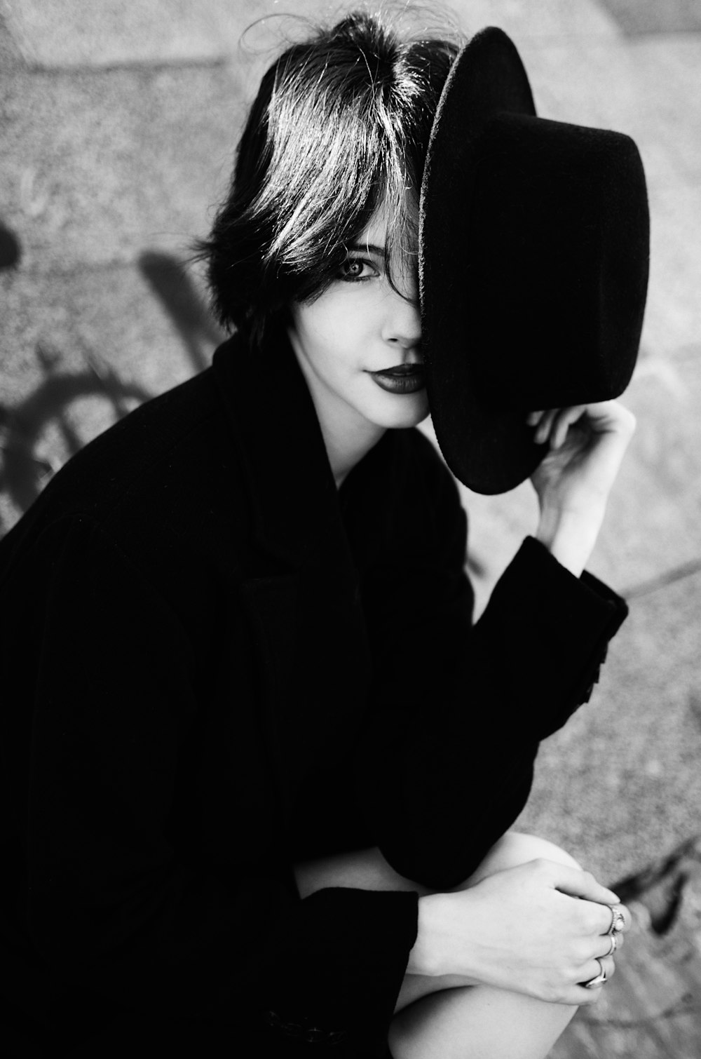 a black and white photo of a woman wearing a hat