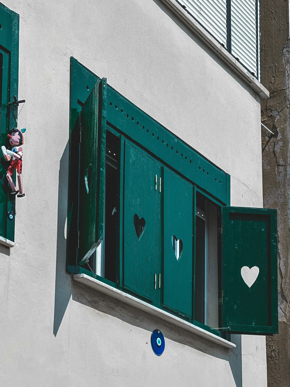 a building with green shutters and a heart cut out of the window