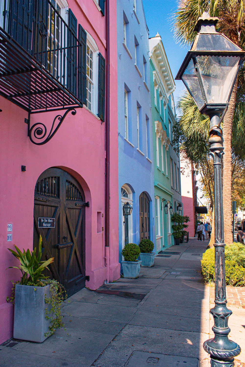 a street light sitting next to a pink building