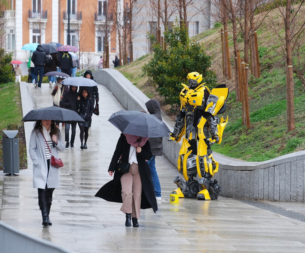 a group of people walking down a sidewalk holding umbrellas