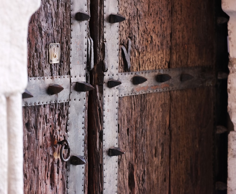 a close up of a wooden door with metal handles