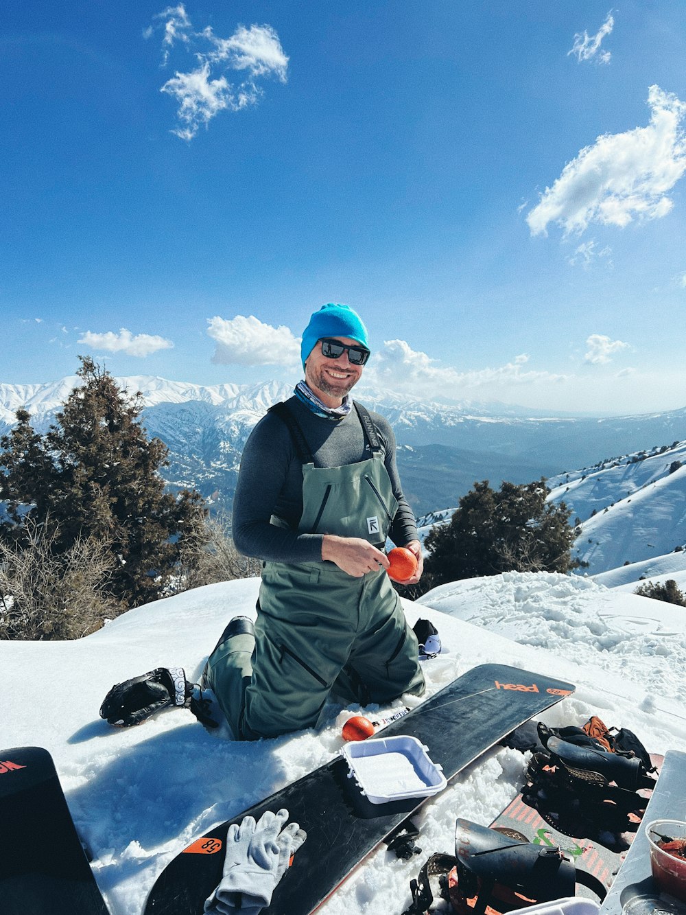 a man sitting on top of a snow covered slope