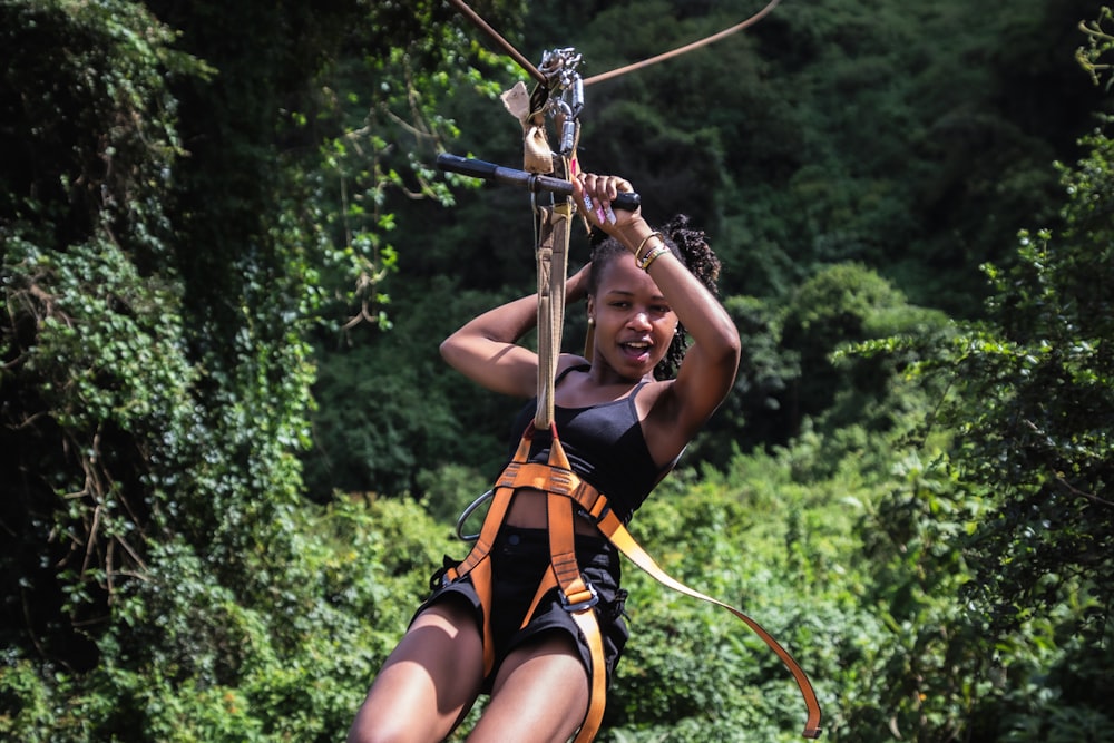 a woman on a zip line in the jungle