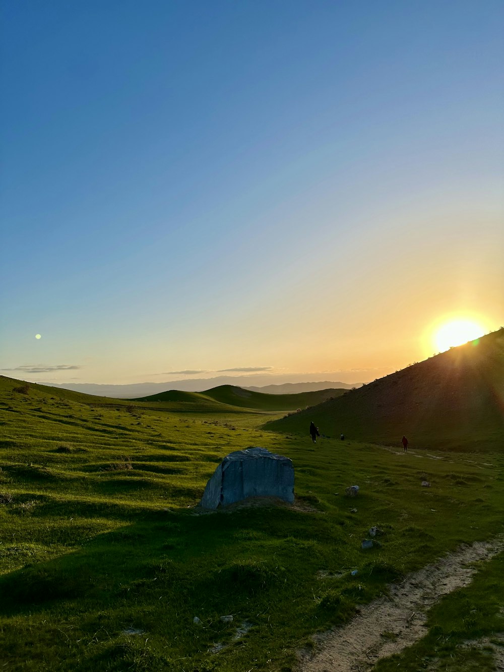 a grassy field with a tent in the distance