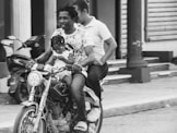 a black and white photo of a man and a woman on a motorcycle