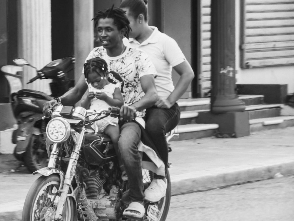 a black and white photo of a man and a woman on a motorcycle