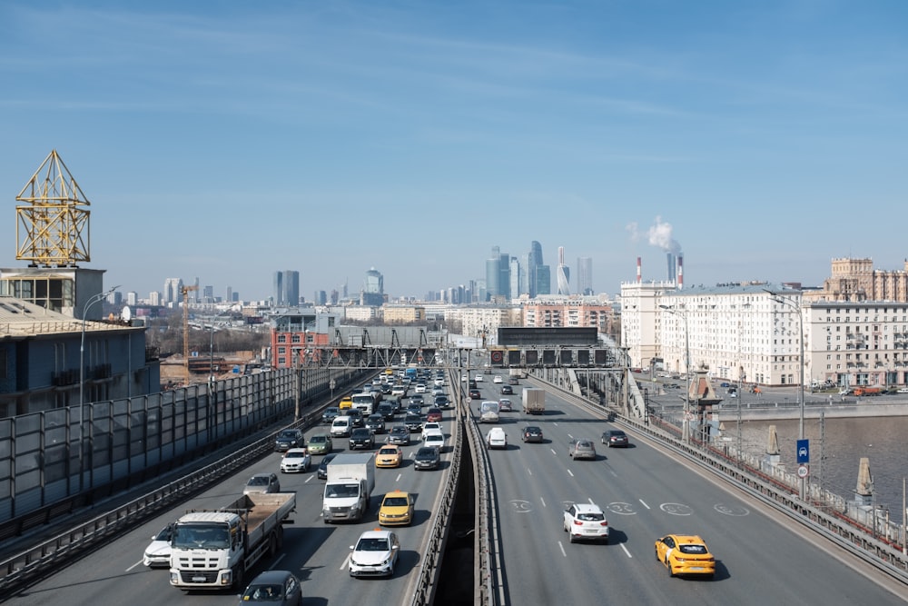 a highway filled with lots of traffic next to tall buildings