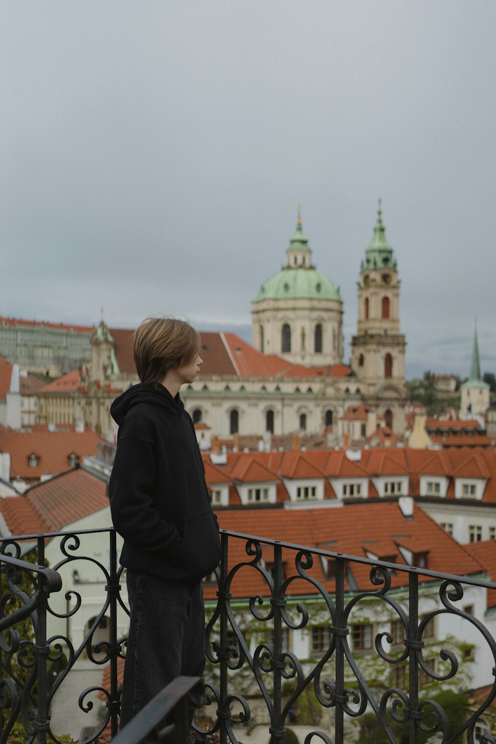 a woman standing on a balcony overlooking a city