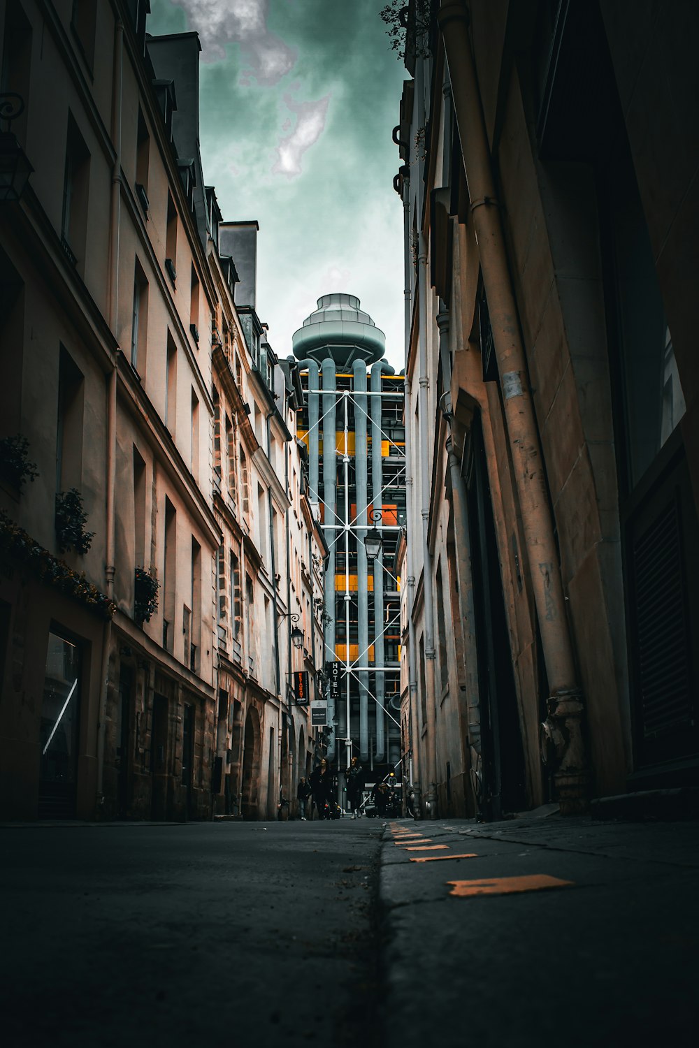 a narrow city street with a tall building in the background