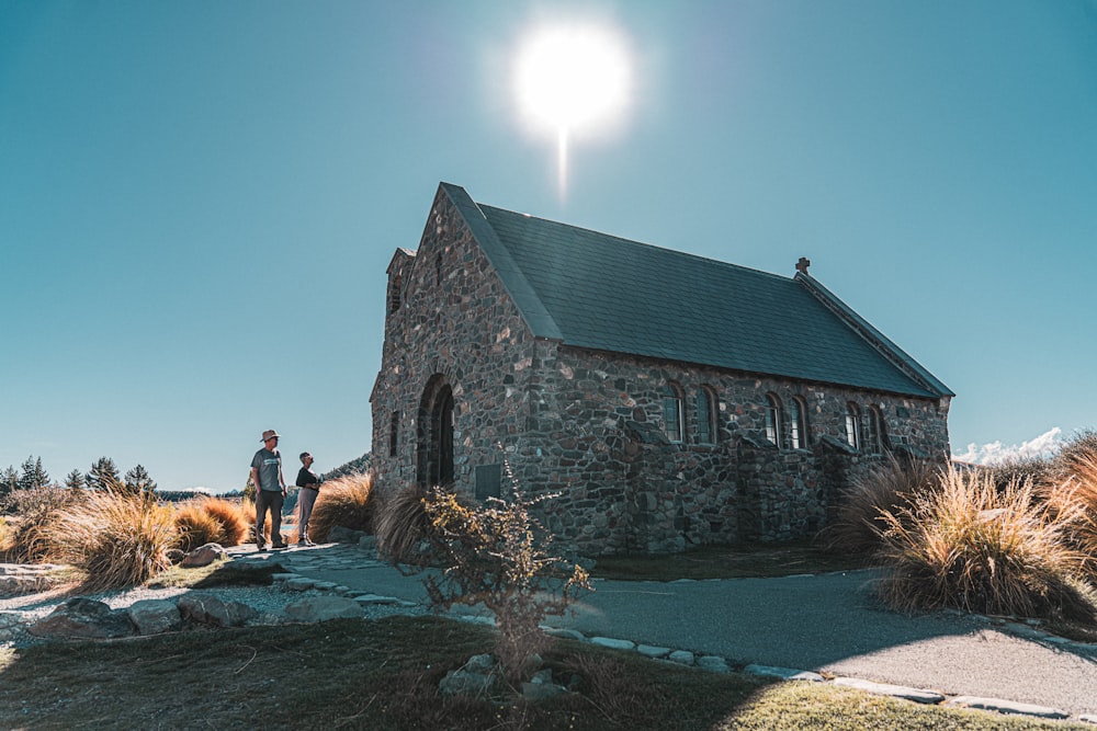 two people standing in front of a stone church