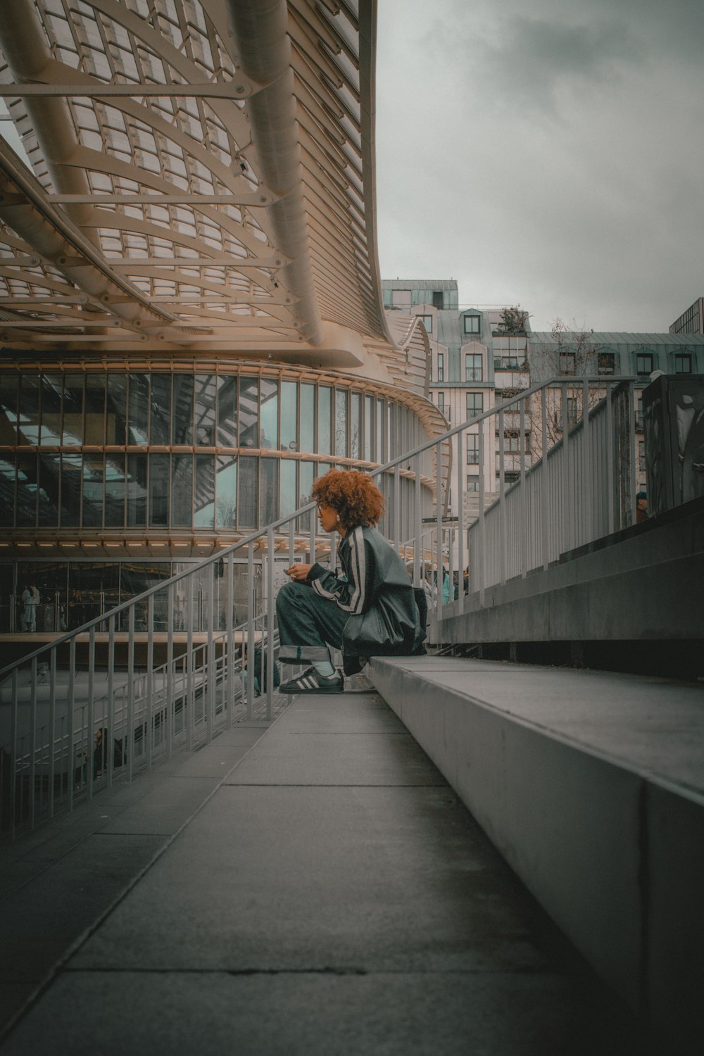 a woman with red hair sitting on a ledge