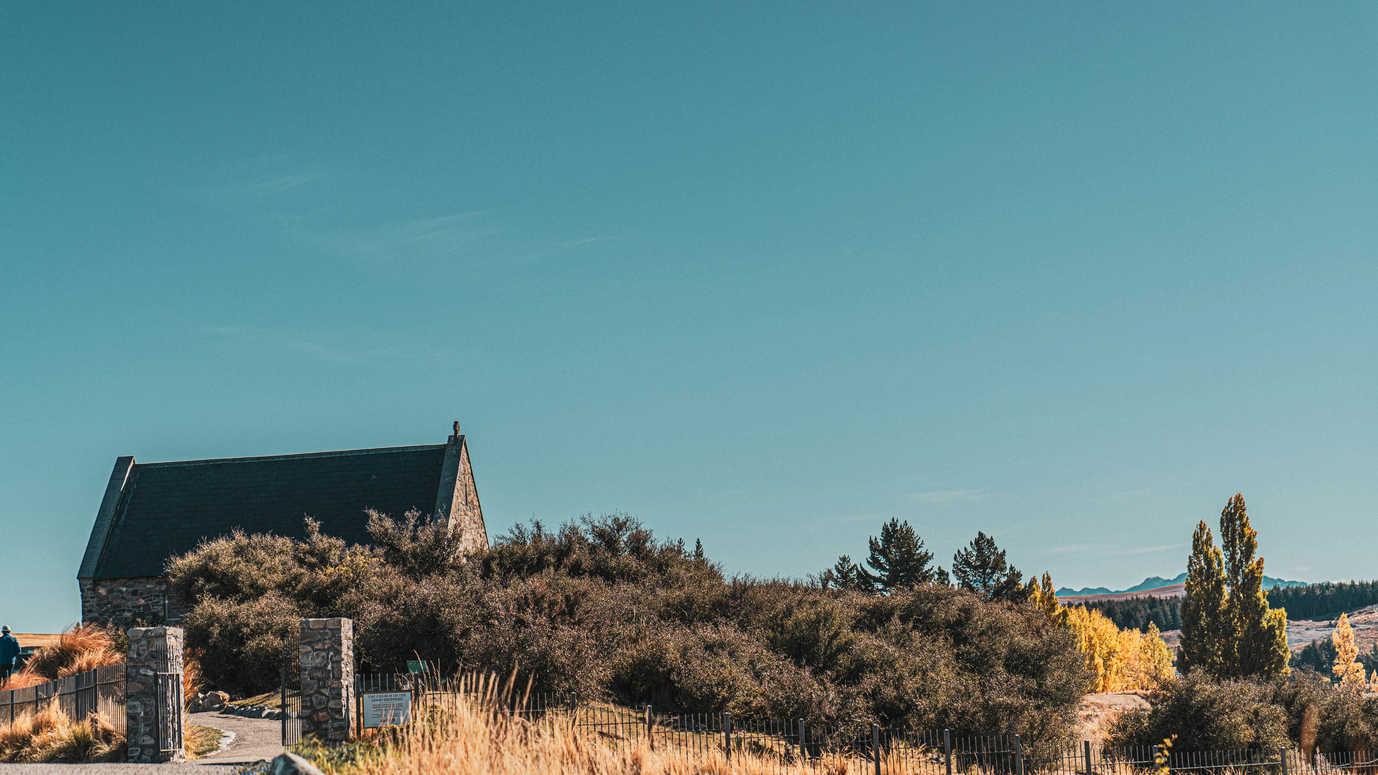 a small church on a hill with a fence around it