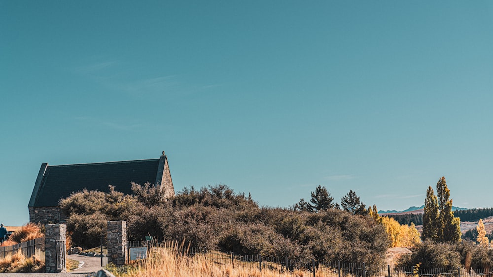 a small church on a hill with a fence around it