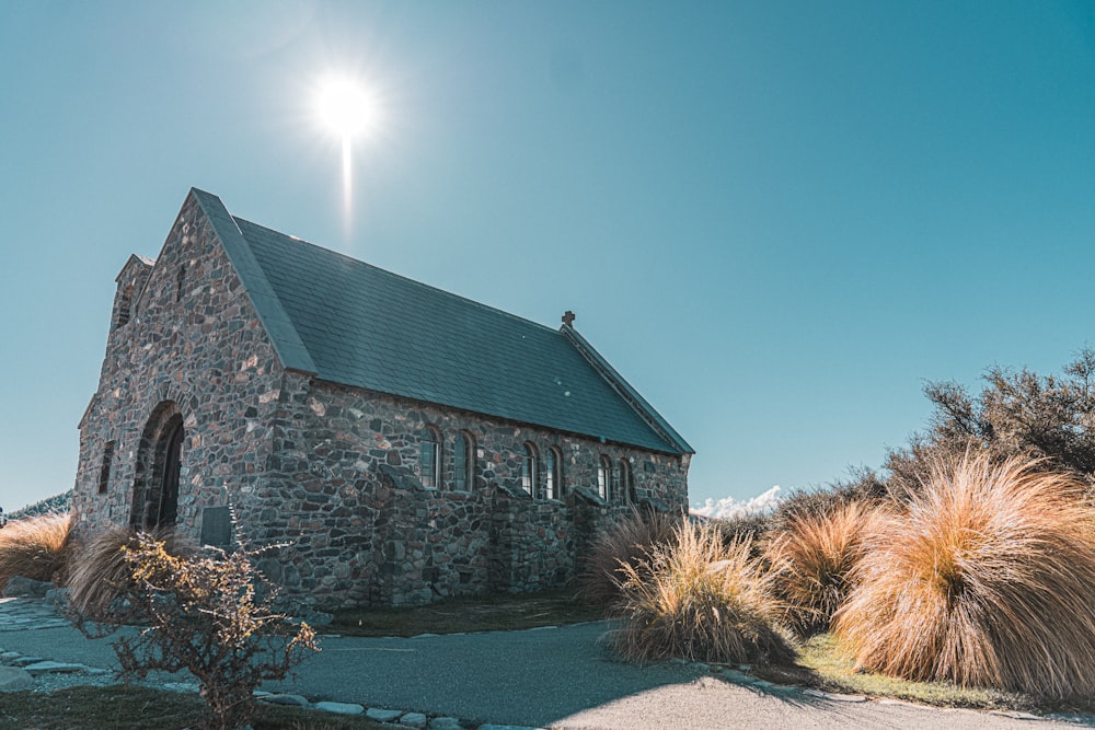 a stone church with a steeple surrounded by grass