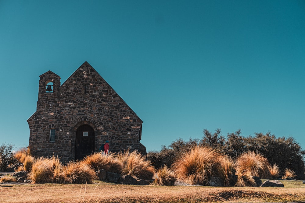 a stone church with a bell tower on top of a hill