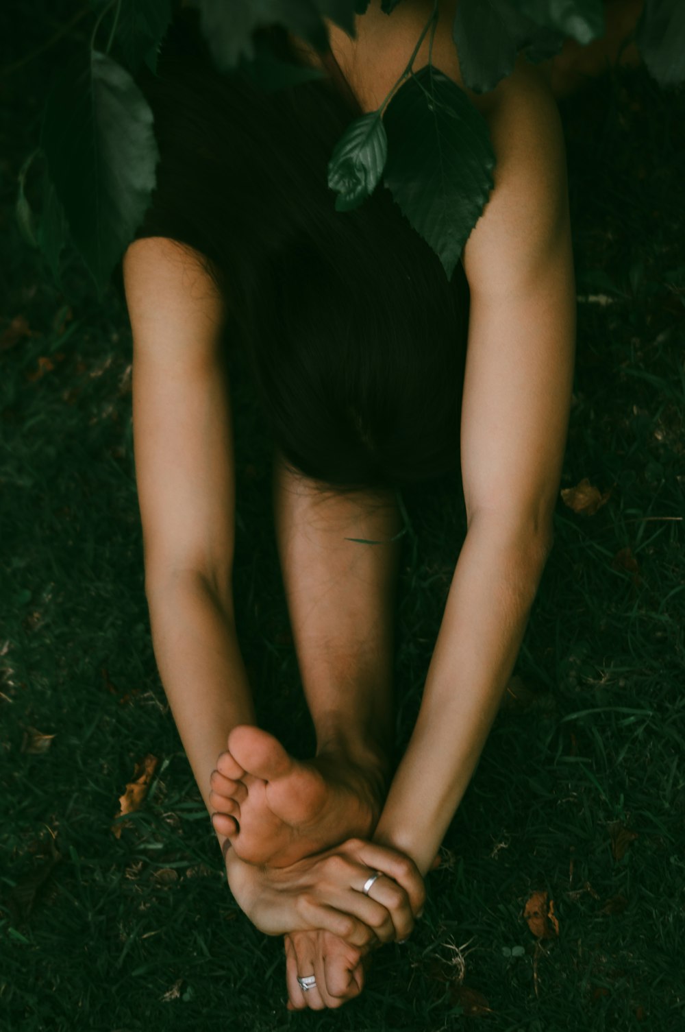 a person laying on the ground with their hands on their knees