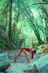 a woman is doing yoga in the woods