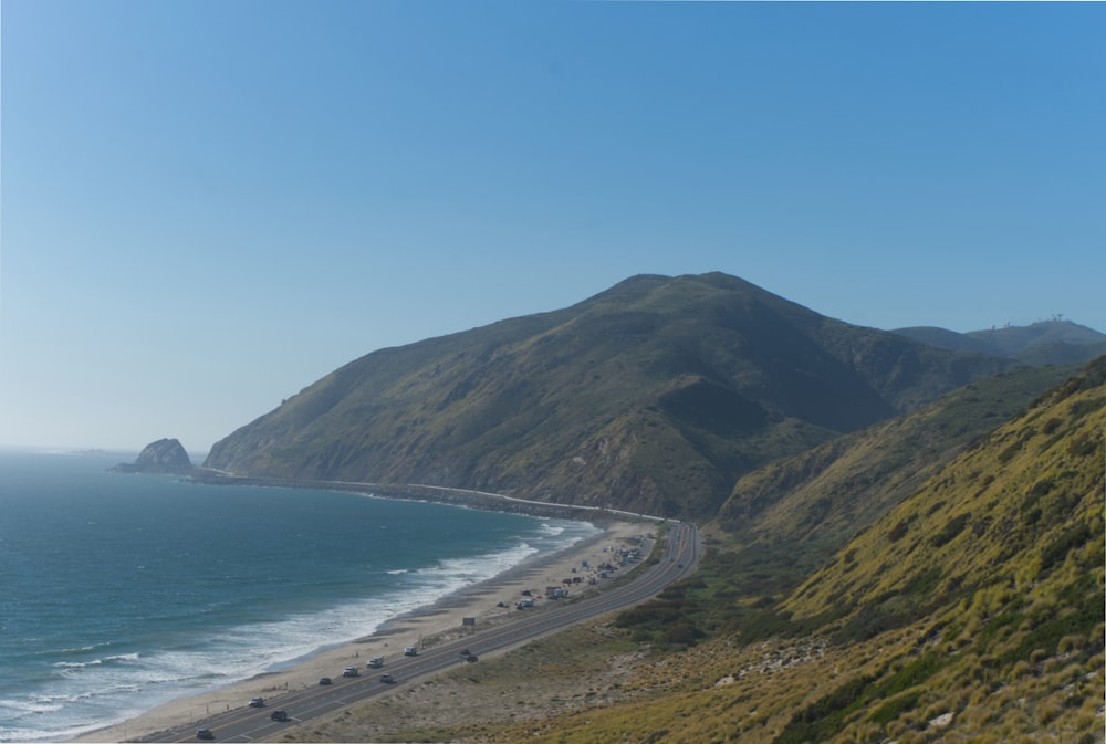 a view of a beach and mountains from a hill