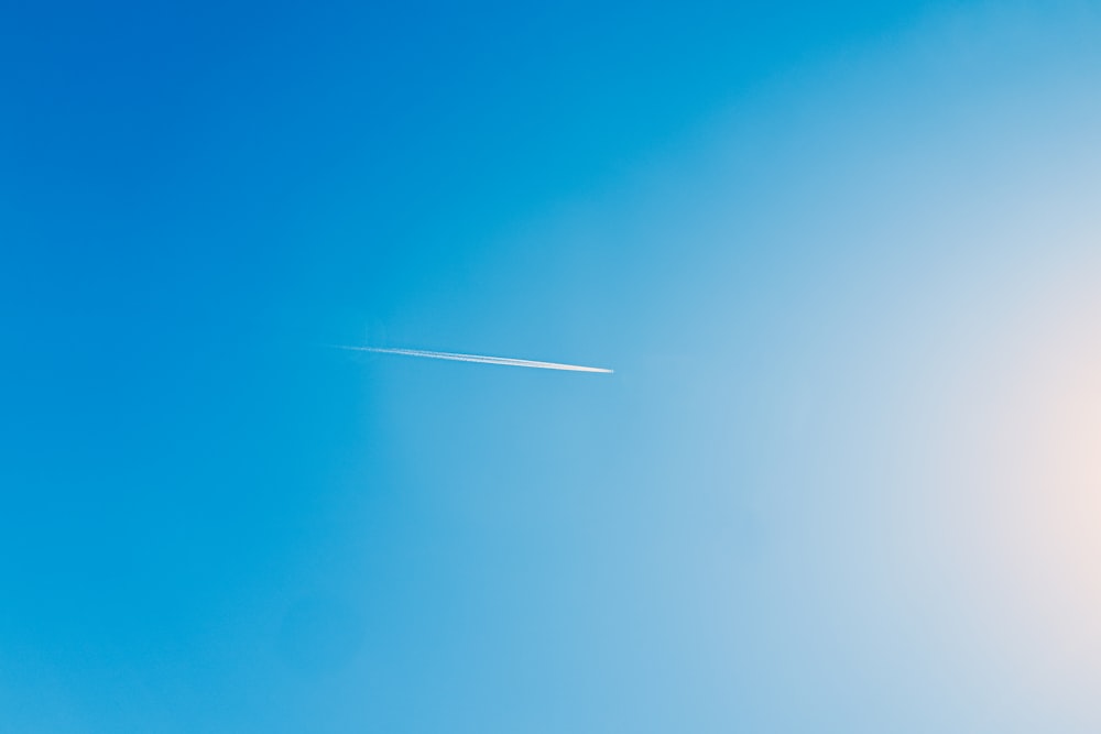 an airplane is flying in the blue sky